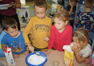 Dzieci mieszają składniki na ciasto.