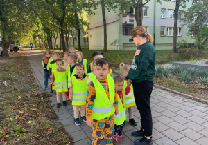 Dzieci słuchają, co oznaczają napotkane znaki drogowe.