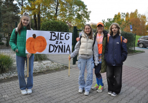 Wolontariuszki wraz z nauczycielem i banerem biegu.