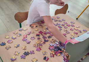 Dziewczynka układa puzzle.