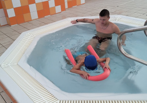 Chłopiec ćwiczy pływanie w jacuzzi.