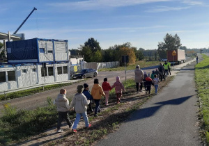 Dzieci w parach ida na teren budowy.