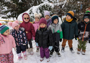 Dzieci spacerują po terenie ogrodu w poszukiwaniu karmników.