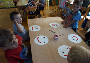 Dzieci pokazują namalowane buźki z uśmiechem.
