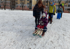 Dziewczynka zjeżdża na sankach.