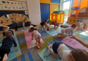 Dzieci unosza nogę do góry.