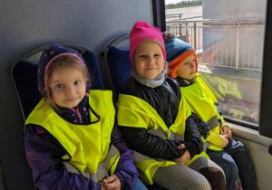 Dzieci jadą autobusem lotniskowym po terenie portu lotniczego.