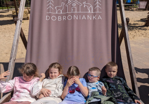 Dzieci siedzą na ogromnym leżaku.