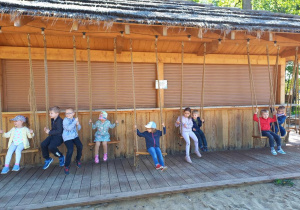 Dzieci huśtają się na huśtawkach z lin.