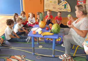 Nauczycielka pokazuje owoce.