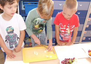 Dzieci kroją owoce.