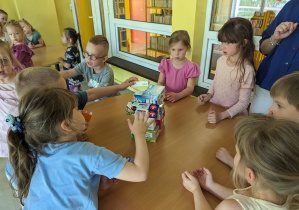 Dzieci budują wieżę z pudełek.