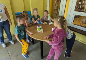 Dzieci budują wieżę z pudełek.