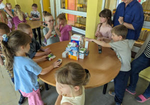 Dzieci budują wieżę z pudełek.