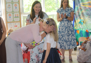Dzieci otrzymują dyplomy zakończenia edukacji przedszkolnej.