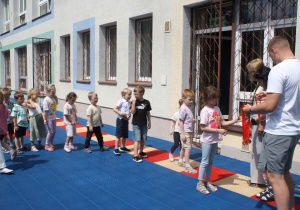 Dzieci otrzymują medale za udział w zajęciach na basenie.