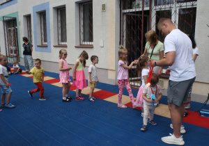 Dzieci otrzymują medale za udział w zajęciach na basenie.