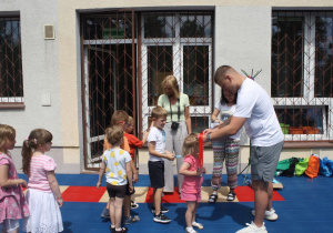 Dzieci otrzymują medale za udział w zajęciach na basenie.