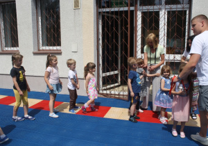 Dzieci otrzymują medale za udział w zajęciach na basenie.
