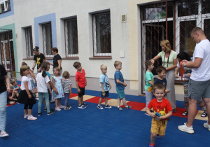 Dzieci otrzymują medale za udział w zajęciach na basenie.