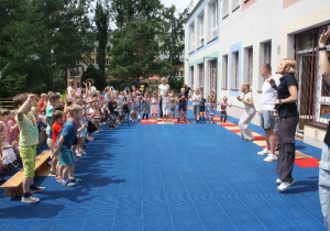 Dzieci wykonują sportowy okrzyk.