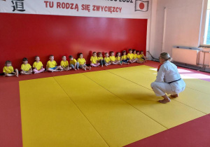 Dzieci uczestniczą w treningu judo.