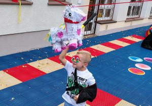 Dzieci rozbijają piniatę.