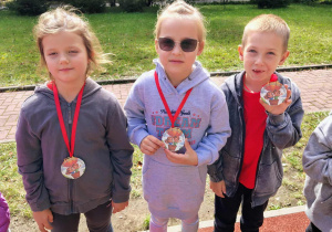 Dzieci pozują z medalami.