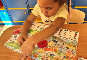 Dziewczynka koloruje kwiatek.