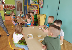 Dzieci słuchają nauczycielki jak przygotować deser