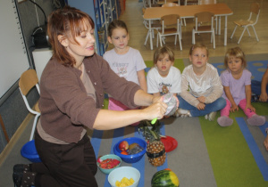 Nauczycielka kroi owoce.
