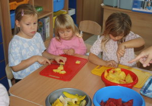 Dzieci kroją owoce.