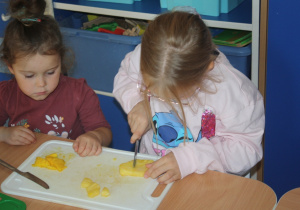 Dzieci kroją owoce.