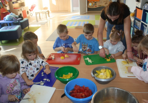 Dzieci kroją owoce.