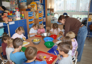 Dzieci kroją owoce.