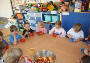 Dzieci jedzą sałatkę.