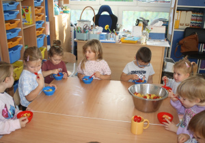 Dzieci jedzą sałatkę.