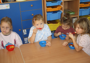 Dzieci jedzą sałatkę.