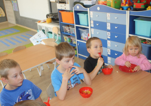 Dzieci jedzą sałatkę.