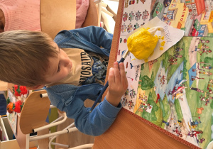 Chłopiec maluje farbą swoje warzywo.