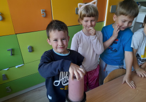 Chłopiec miksuje owoce w blenderze.