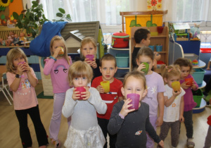 Dzieci piją świeżo wyciskany sok z buraka.