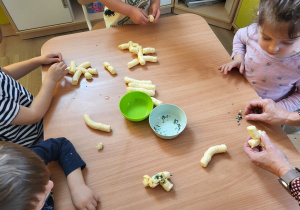 Dzieci wykonują figurki z chrupek kukurydzianych.