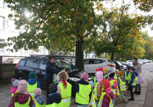 Dzieci szukają żołędzi w parku.