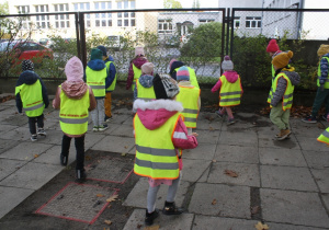 Dzieci szukają żołędzi w parku.