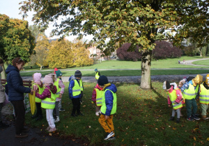 Dzieci szukają kasztanów w parku.