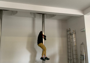 Strażąk zjeżdża rurą na akcję.