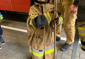 Dziecko pozuje do zdjęcia w stroju strażaka.