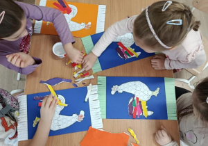 Dzieci wykonują pracę plastyczną - koguty na ręcznikach.