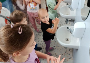 Dzieci myją ręce w łazience.